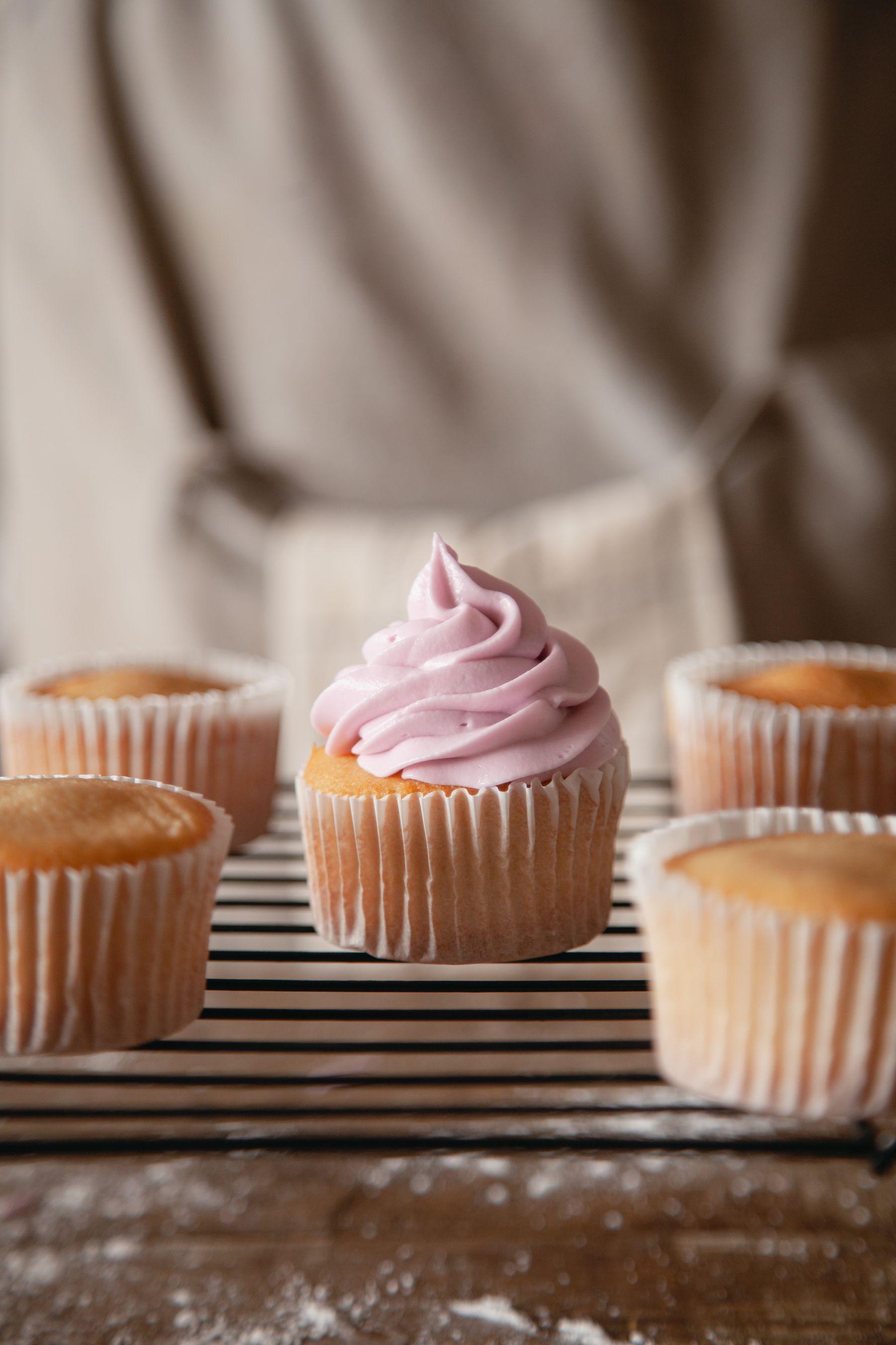 A cupcake with a tall swirl of pink buttercream